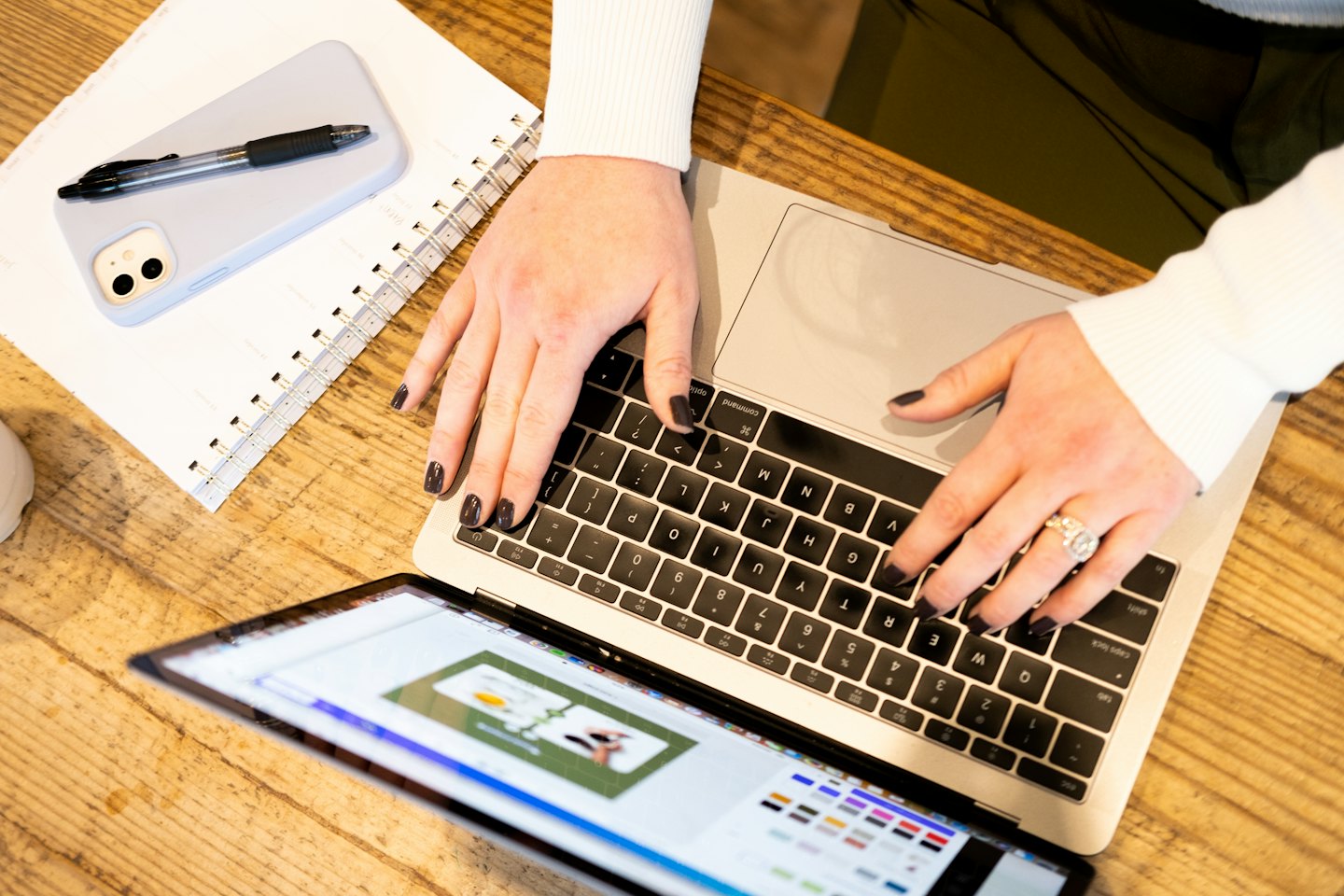 Person types on a laptop with a design interface open.